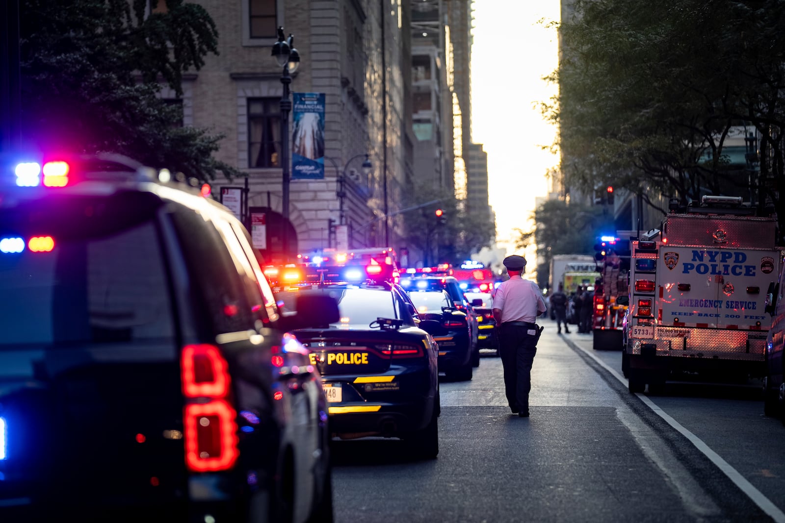 A New York police officer stands watch on 52nd Street outside a Manhattan office building where at least two people were shot, including a police officer, Monday, July 28, 2025, in New York. (AP Photo/Angelina Katsanis)