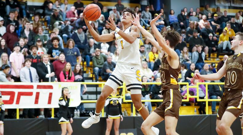 Shawnee High School senior Zion Crowe drives to the hoop while being guarded by Kenton Ridge junior Ckai Rogan during their game on Friday, Jan. 27, in Springfield. Crowe scored 18 points in the game to become the school's career points leader. Michael Cooper/CONTRIBUTED