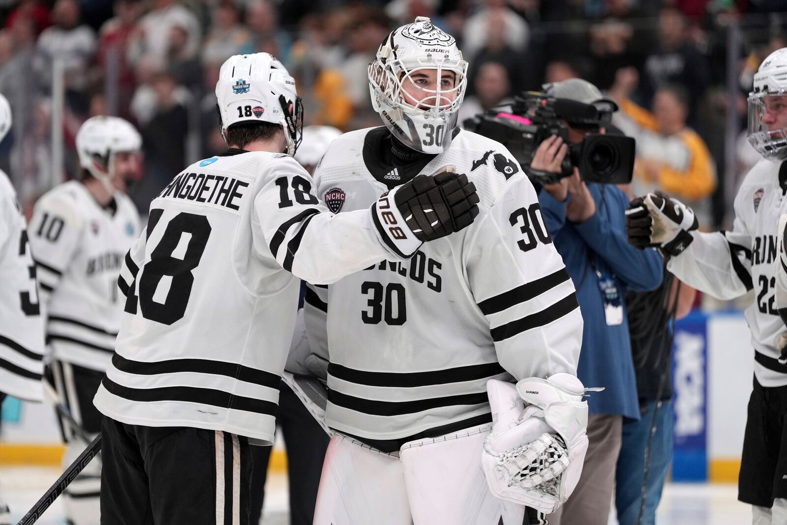 Western Michigan goaltender Hampton Slukynsky (30) and teammate Wyatt Schingoethe (18) celebrate a double overtime victory over Denver in a semifinal game in the NCAA Frozen Four men's college hockey tournament, Thursday, April 10, 2025, in St. Louis (AP Photo/Jeff Roberson)