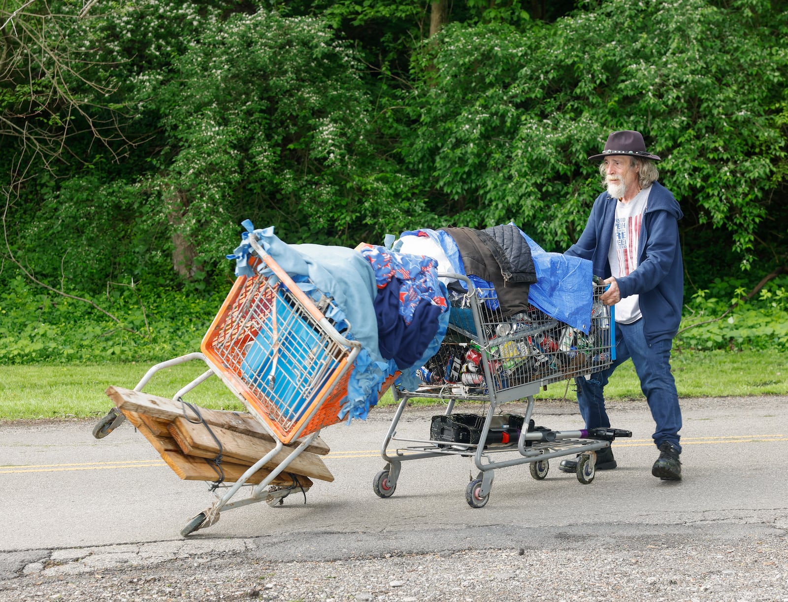 A man identified as "Thomas" carries his belongings as he leaves a homeless encampment on Monday, May 5, 2025, at Snyder Park. He lived there for a year and a half. JOSEPH COOKE/STAFF