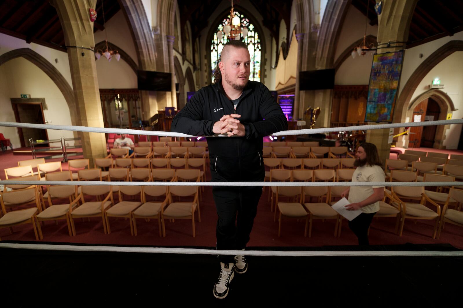 Gareth 'Angel' Thompson, founder of the Kingdom Wrestling charity stands ringside at St Peter's Church in Shipley before one of the charity's monthly wrestling shows, Saturday, March 29, 2025. (AP Photo/Jon Super)