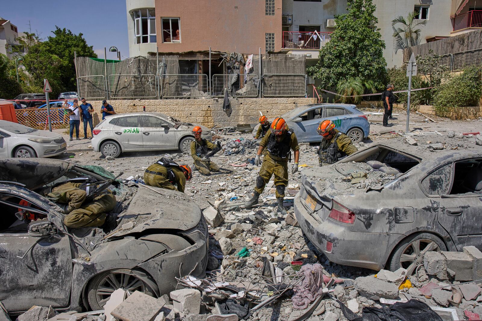 Israeli soldiers work amid the rubble of residential buildings destroyed by an Iranian missile strike that killed several people, in Beersheba, Israel, on Tuesday, June 24, 2025. (AP Photo/Bernat Armangue)