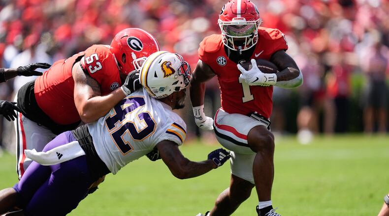 Georgia running back Trevor Etienne (1) breaks through the line of scrimmage as lineman Dylan Fairchild (53) blocks Tennessee Tech linebacker Kalvyn Crummie (42) during the first half of an NCAA college football game Saturday, Sept. 7, 2024, in Athens, ga. (AP Photo/John Bazemore)