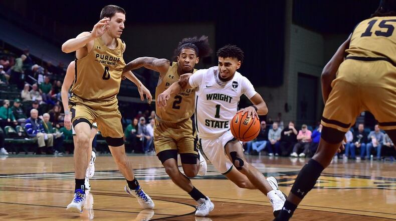 Wright State's Trey Calvin drives past Purdue Fort Wayne's Bobby Planutis (0) and Damian Qui Chong at the Nutter Center on Jan. 19, 2023. Joe Craven/Wright State Athletics
