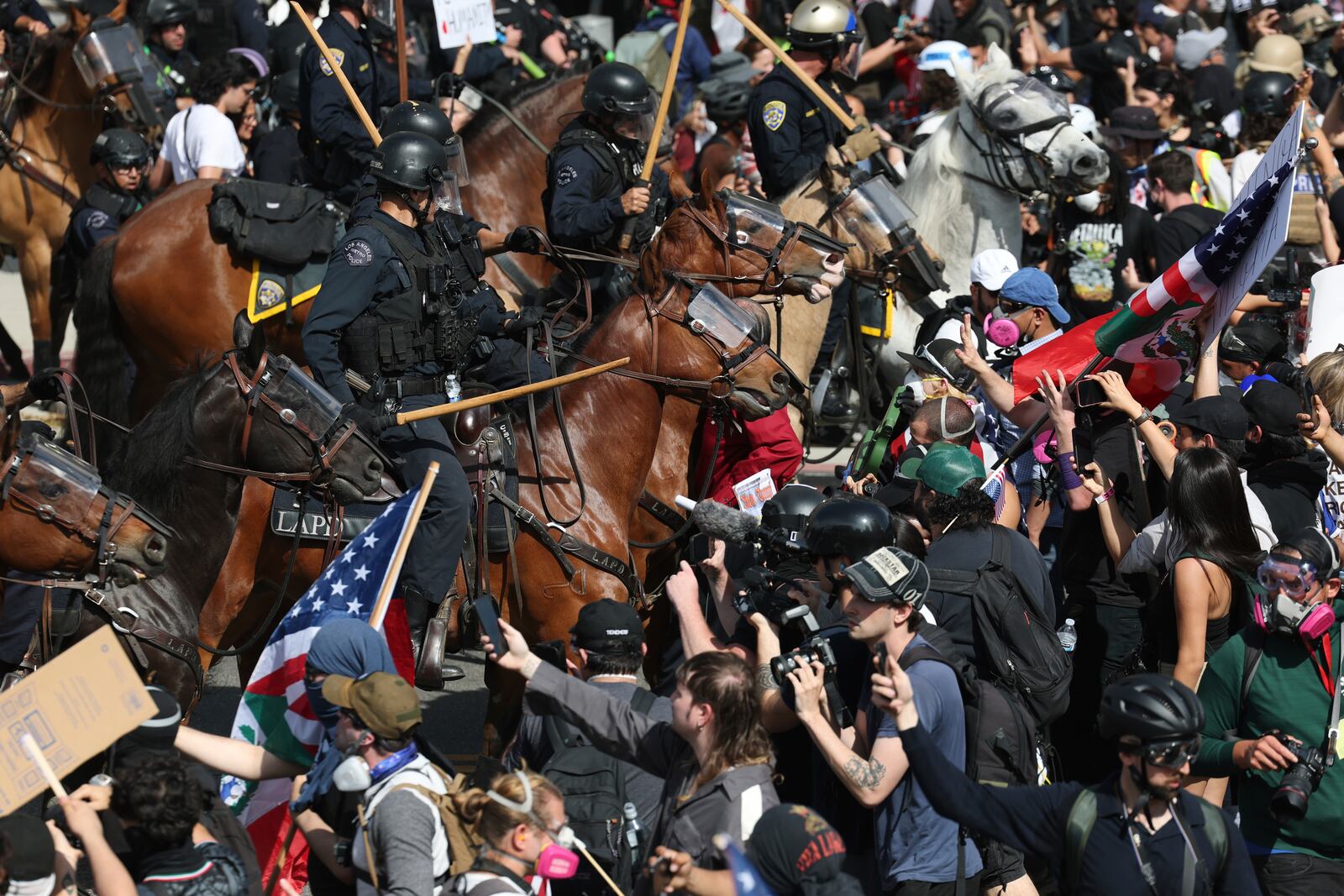 Demonstrators standoff against law enforcement on horseback during a protest Saturday, June 14, 2025, in Los Angeles. (AP Photo/Ethan Swope)