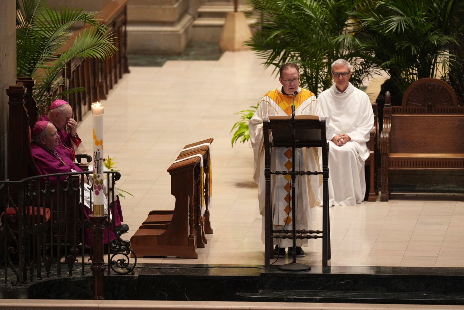 Father Dan Griffith, at podium, speaks as Archbishop Bernard Hebda, listens during funeral services for Mark and Melissa Hortman at the Basilica of St. Mary in Minneapolis, Minn., on Saturday, June 28, 2025. (Alex Kormann/Star Tribune via AP, Pool)