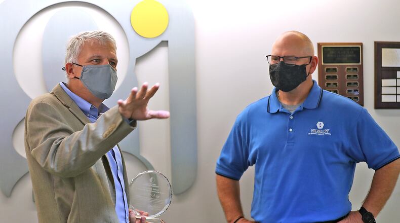 Glenn Daehn, left, an engineering professor at Ohio State University and member of the ASM Materials Education Foundation, presents Scott Spohler, a teacher at the Global Impact STEM Academy, with the 2021 Kishor M. Kulkarni Distinguished High School Award Friday at the School. BILL LACKEY/STAFF