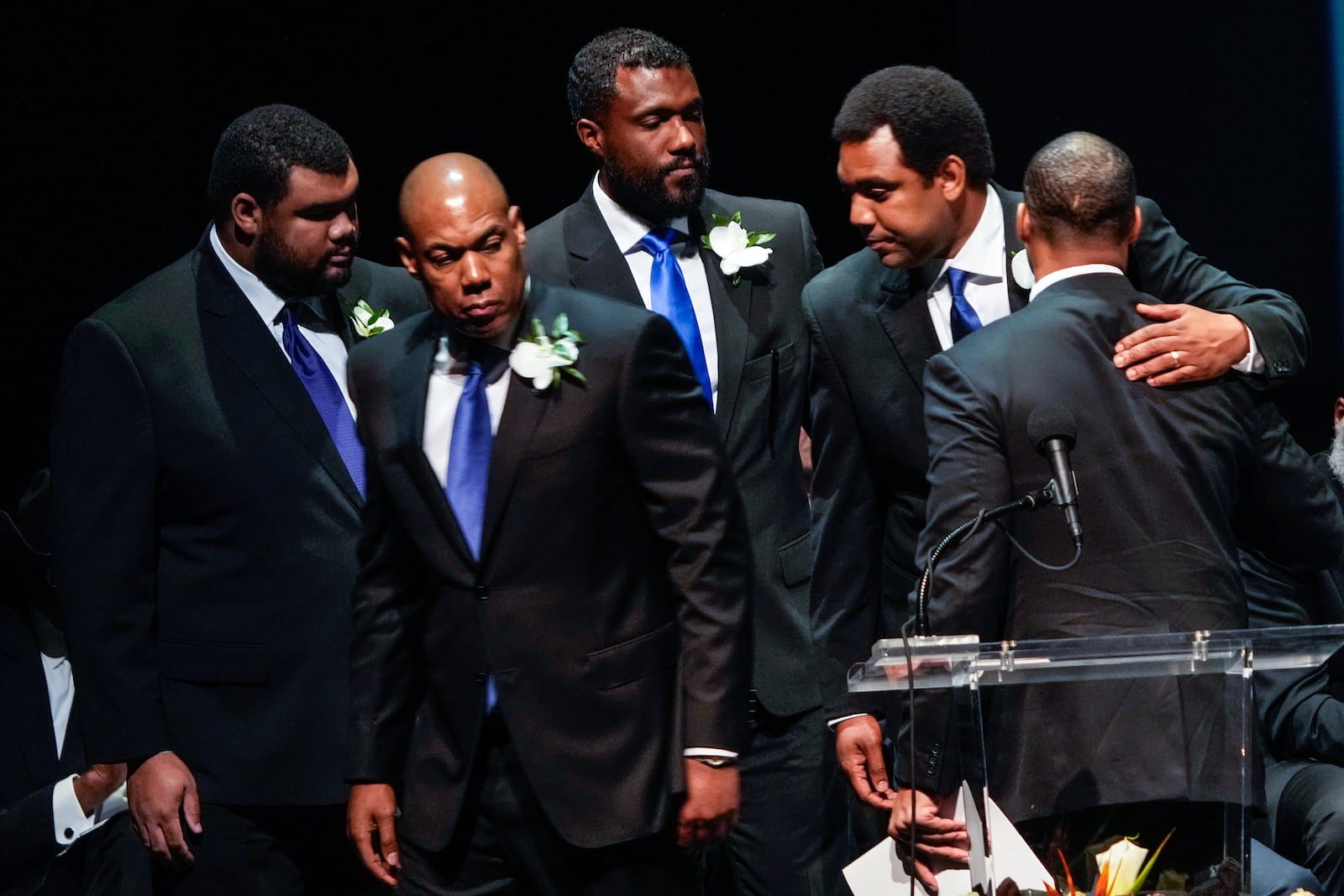 George Foreman IV, right embraces his brothers as they leave the stage following the eulogy for their father during a memorial service for Olympic and world champion boxer and minister George Foreman at Wortham Theater Center in Houston, Monday, April 14, 2025. (Brett Coomer/Houston Chronicle via AP)