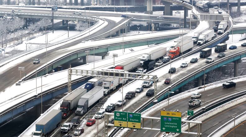 FILE - Tractor trailers and other vehicles are at a stand still as they exit the Brent Spence Bridge near downtown Cincinnati heading toward Ft. Washington Way, Feb. 9, 2021. According to a recent announcement by Kentucky and Ohio they will receive more than $1.63 billion in federal grants to help build a new Ohio River bridge near Cincinnati and improve the existing overloaded span there, a heavily used freight route linking the Midwest and the South. (Cara Owsley/The Cincinnati Enquirer via AP, File)