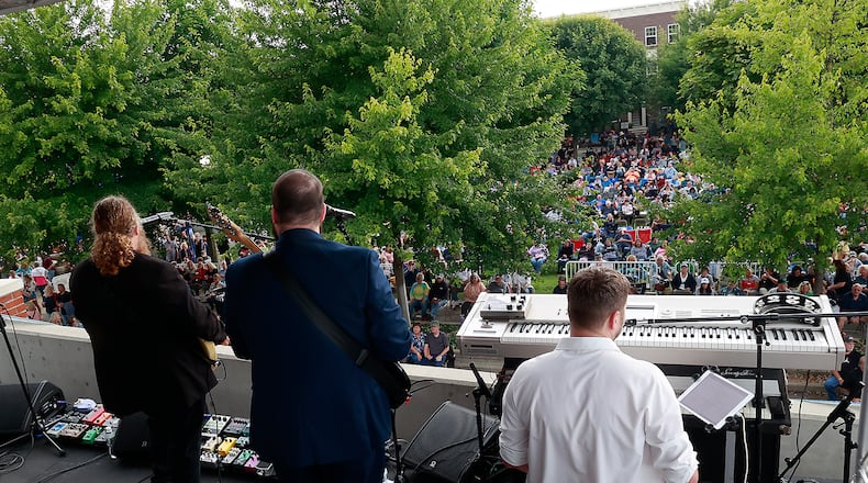 Hundreds of people gathered in National Road Commons Park in downtown Springfield for the Come Together Springfield 2023 - A Rooftop Beatles Tribute Friday, June 16, 2023. The Beatles tribute band played from the top of the city parking garage over looking the sea of music lovers that covered the park in their lawn chairs and blankets. The event, sponsored by Skyline Chili in conjuction with the Greater Springfield Partnership, also featured a variety of food trucks and refreshments. BILL LACKEY/STAFF