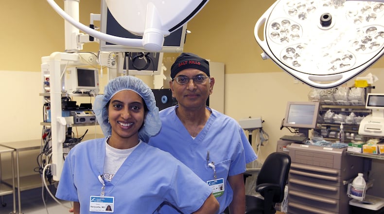 Dr. Surender Neravetla and Dr. Soumya Neravetla pose together in an operating room at the Springfield Regional Medical Center. Soumya has been working with her father in Springfield for the past several months. Bill Lackey/Staff