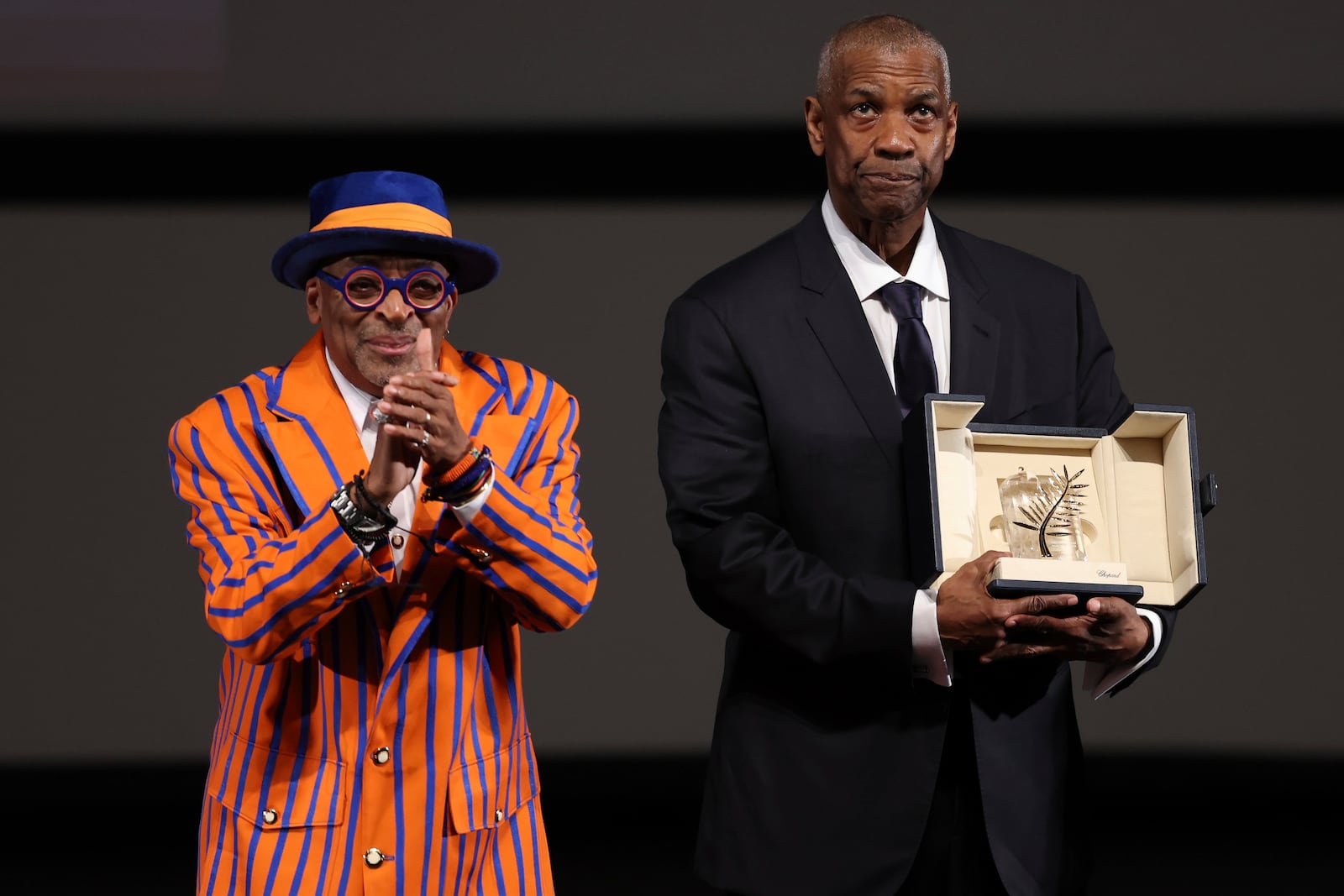 Actor Denzel Washington receives an Honorary Palme d'Or (Golden Palm) from director Spike Lee, left, ahead of the screening of the film "Highest 2 Lowest" at the 78th edition of the Cannes Film Festival in Cannes, southern France, Monday, May 19, 2025. (Sameer Al-Doumy, Pool via AP)
