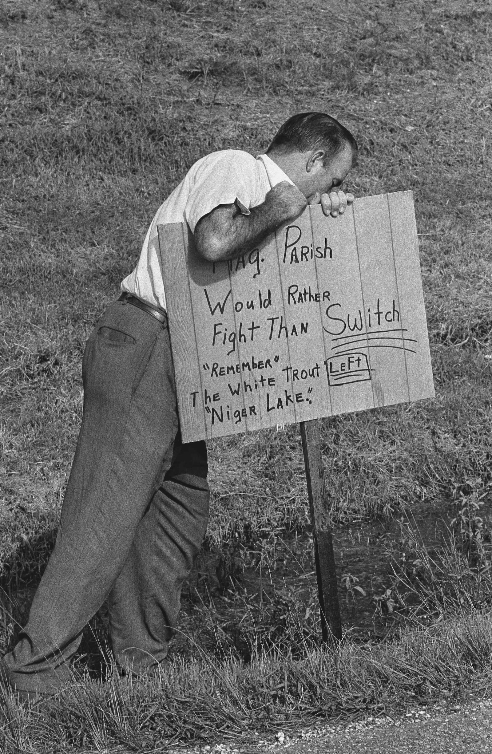 FILE - A man plants a sign reading outside Woodlawn High School in Pointe a la Hache, Louisiana on Sept. 1, 1966 where five African Americans applied for registration for the first time in parish history. (AP Photo/Jack Thornell, file)