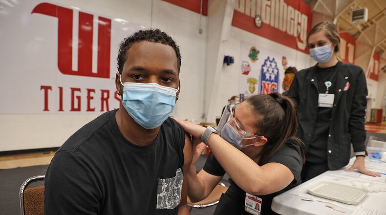 Clark County health officials are urging residents to get vaccinated as cases continue to rise. Kris Thompson, a Wittenberg University student, receives a COVID vaccine shot from Wittenberg nursing student Jillian Connelly during a vaccine clinic earlier this year on campus. BILL LACKEY/STAFF