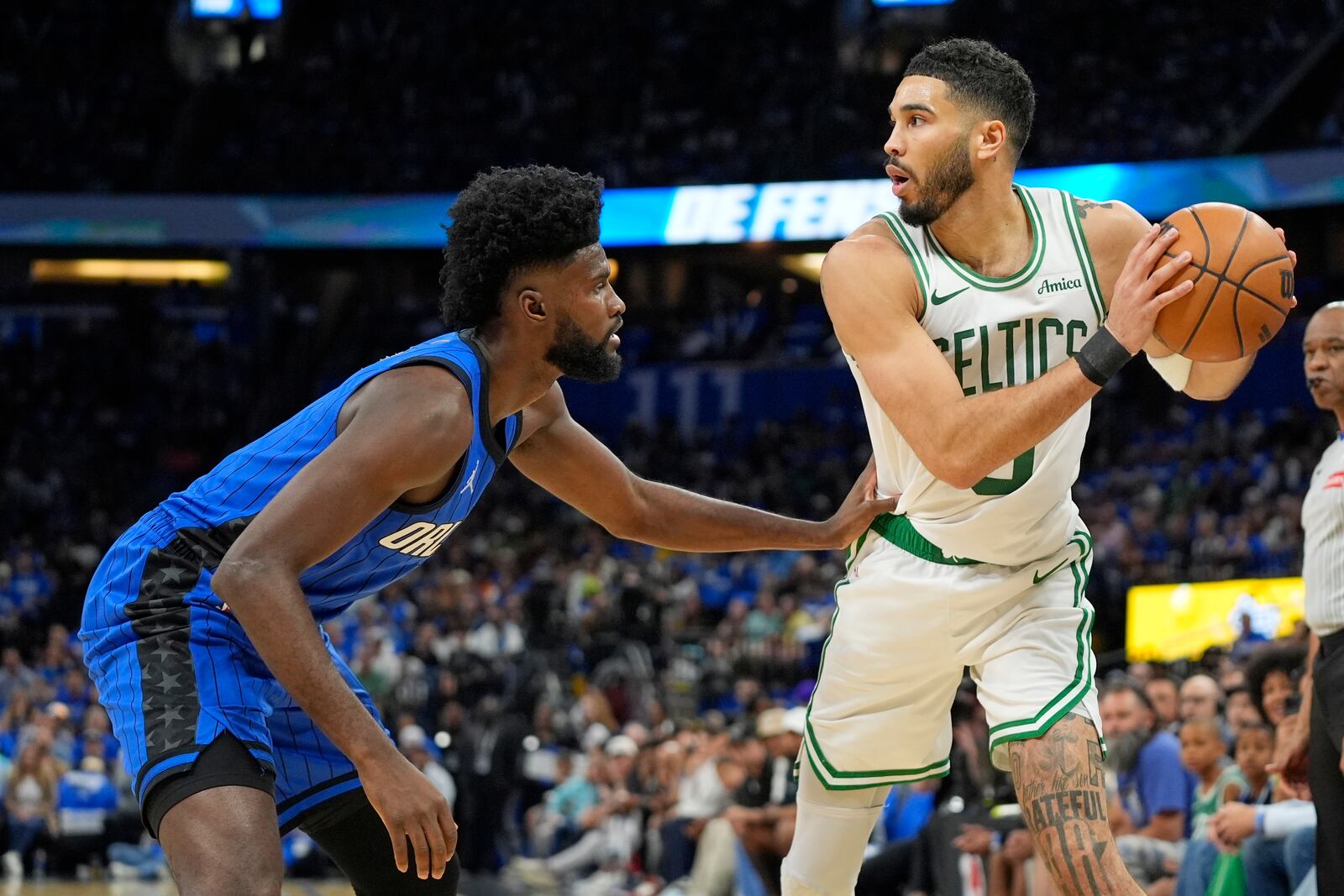 Boston Celtics forward Jayson Tatum, right, looks to pass the ball as he is defended by Orlando Magic forward Jonathan Isaac, left, during the first half in game 3 of a first-round NBA playoff basketball series,, Friday, April 25, 2025, in Orlando, Fla. (AP Photo/John Raoux)