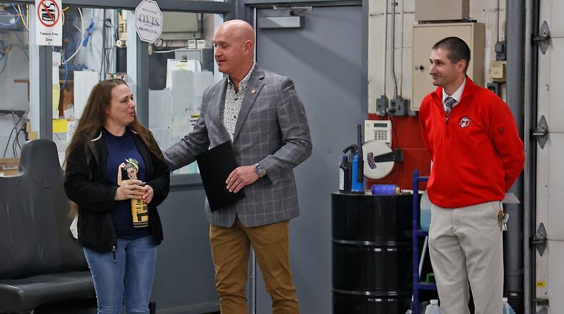 State Representative Bernie Willis, center, was on hand Monday, Feb. 27, 2023 at the Tecumseh Schools transportation garage to recognize April Wise, left, a Tecumseh school bus driver who saved a child last week when a car passed her bus on the right side while she was dropping a child off. Brian Dixon, director of facilities and safety at Tecumseh Schools, is at right. BILL LACKEY/STAFF