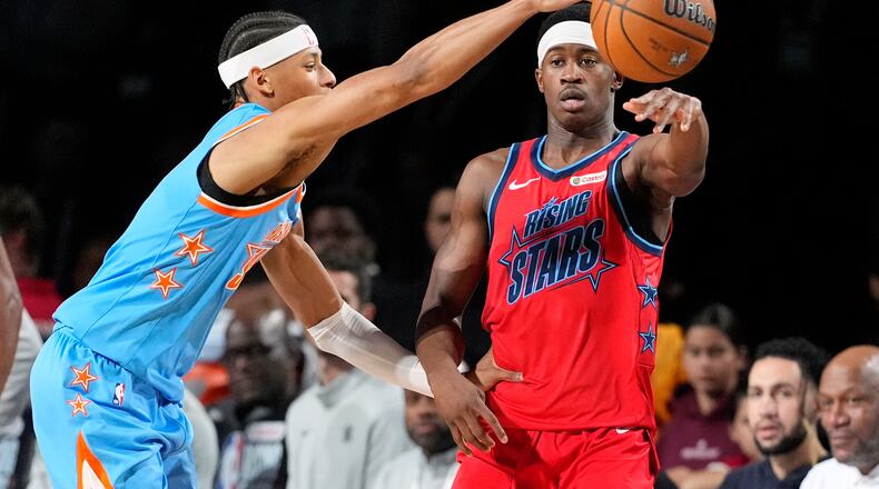 Team Vince guard VJ Edgecombe (77) of the Philadelphia 76ers, right, passes as Team Melo guard Jeremiah Fears (0) of the New Orleans Pelicans defends during a final in NBA basketball's Rising Stars event Friday, Feb. 13, 2026, in Inglewood, Calif. (AP Photo/Mark J. Terrill)