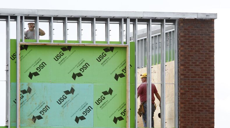 Workers from Dalo Construction are rebuilding the Aldi store in Beavercreek that was struck by a tornado. Framing for store signage is being completed at the corner of the store and interior work has been ongoing for two weeks. TY GREENLEES / STAFF
