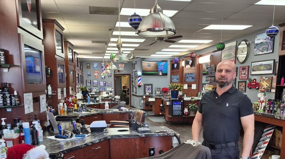 In 2005, Alex Dzhalilov came to the U.S. from Georgia with $7,598. In January, he will open his second barber shop to go along with the four houses he owns. MICHAEL KURTZ / STAFF