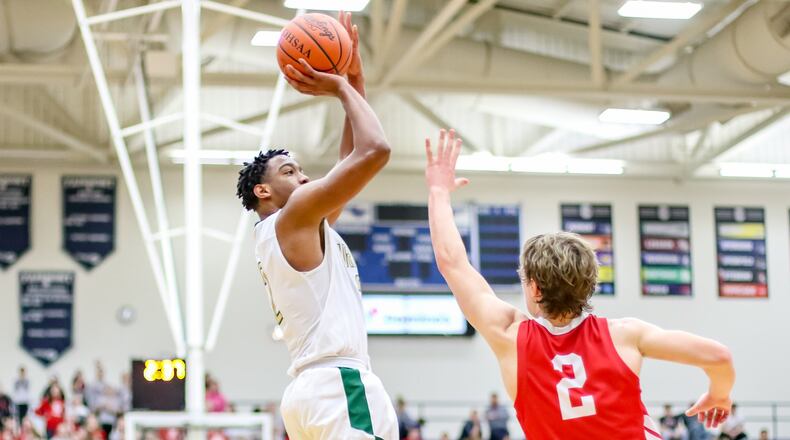 Catholic Central’s Sabien Doolittle shoots the ball over St. Henry’s Jay Knapke during a Division IV regional semifinal game on Tuesday night at Trent Arena in Kettering. St. Henry won 54-36. Catholic Central finished its season 22-4. CONTRIBUTED PHOTO BY MICHAEL COOPER