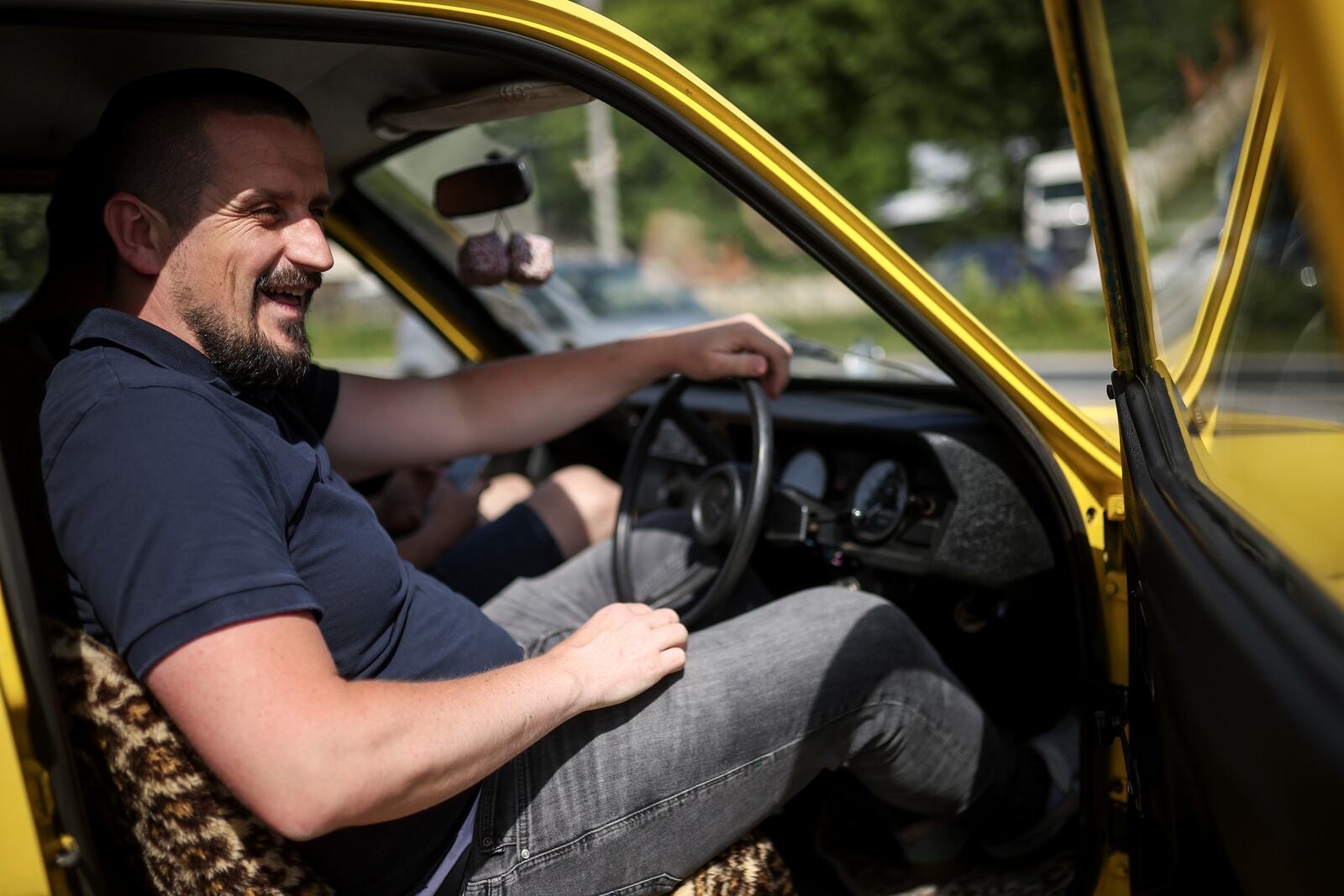 Tarik Fatic sits down in the Reliant Regal, an exact copy of the famous BBC TV show "Only Fools and Horses" iconic yellow car in Hadzici, suburb of Sarajevo, Bosnia, Wednesday, June 4, 2025. (AP Photo/Armin Durgut)