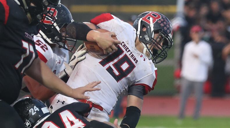 Bellefontaine’s Garrett Gross breaks a tackle by Tecumseh’s Cyle Wells during Friday night’s game. BILL LACKEY/STAFF
