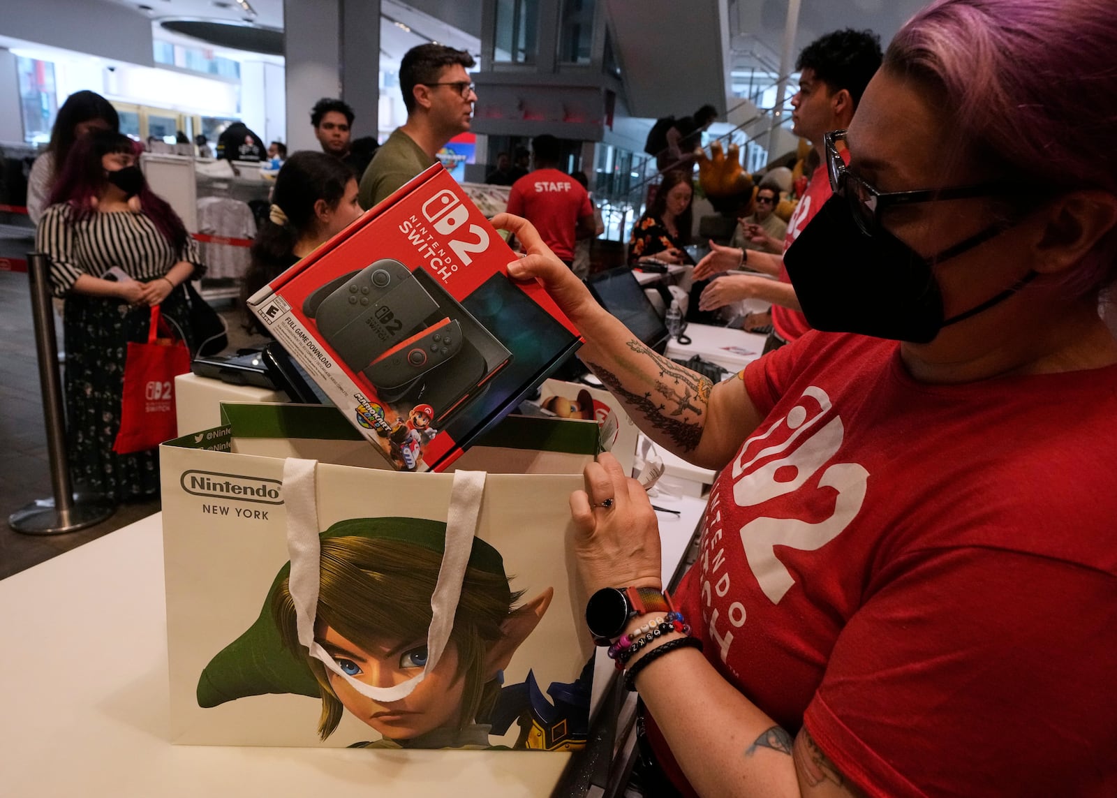 A Nintendo store cashier places a Switch 2 in a bag for a customer at the Nintendo store in New York's Rockefeller Center, Thursday, June 5, 2025. (AP Photo/Richard Drew)