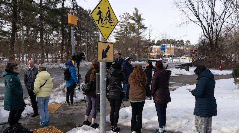 People wait outside Thomas S. Wootton High School for students in Rockville Md., Monday, Feb. 9, 2026, after a person was shot inside the school. (AP Photo/Jose Luis Magana)