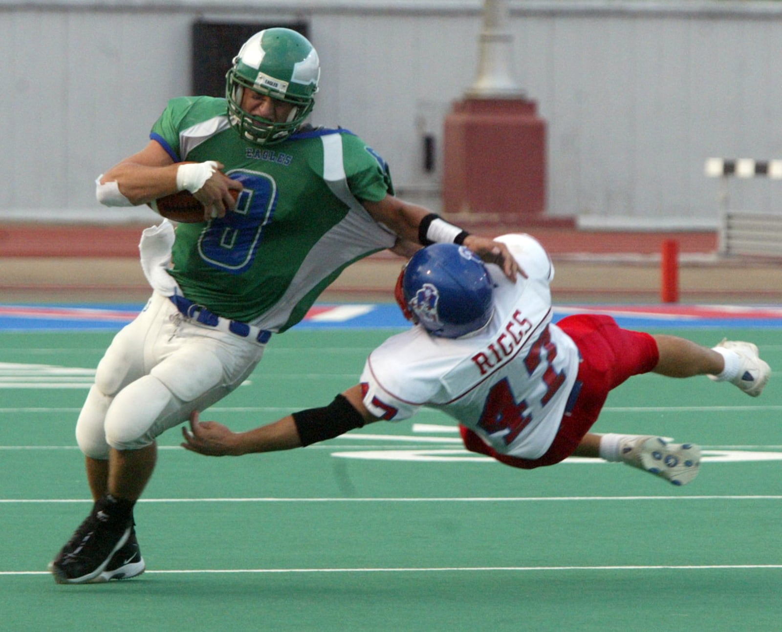 Chaminade-Julienne quarterback Matt Bruggeman is charged by Carroll linebacker Jason Riggs during second quarter of game at Welcome Stadium during their game in 2004. JAN UNDERWOOD / STAFF