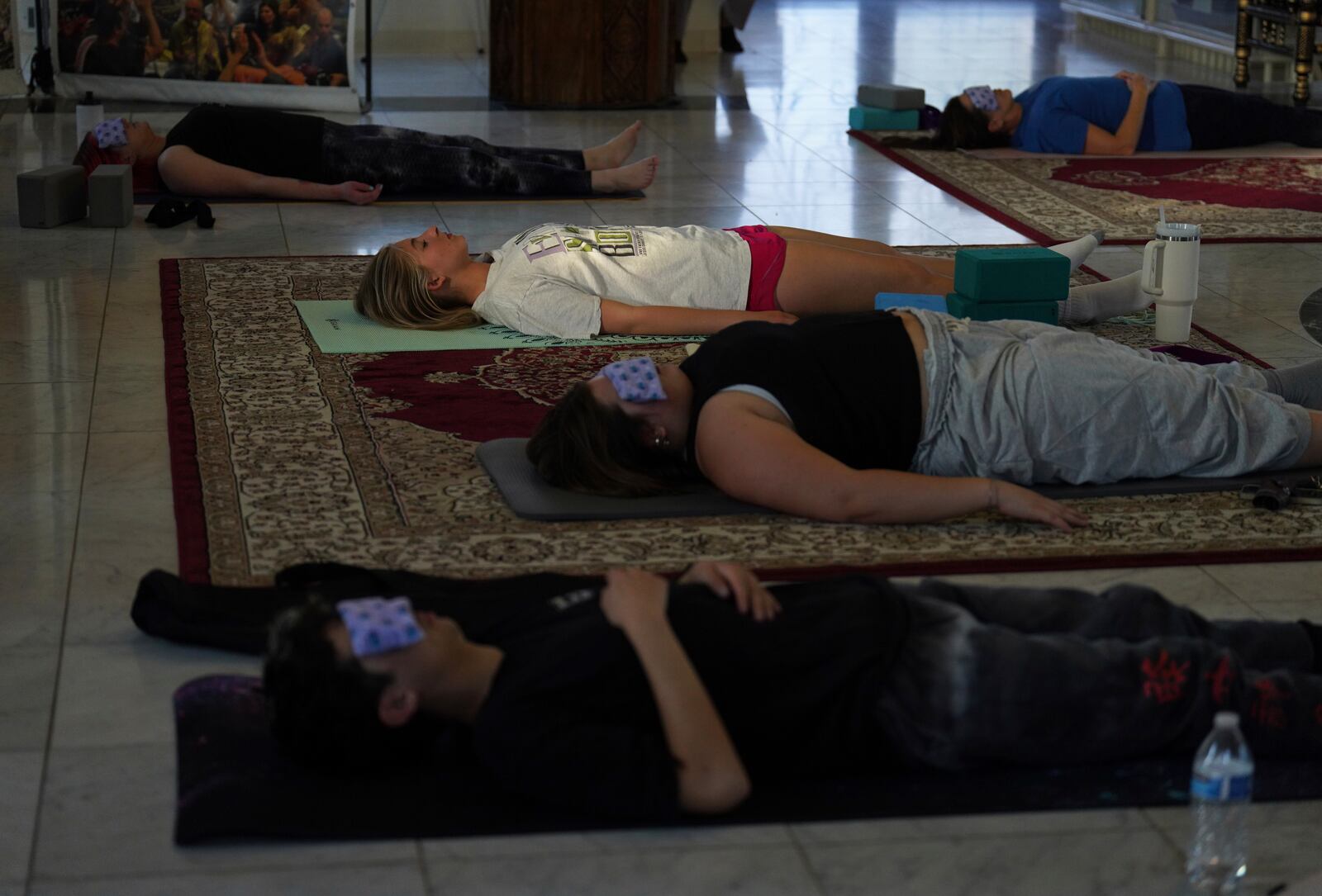 Members of The Church of Jesus Christ of Latter-day Saints lie in "shavasana" or "corpse pose" at the end of a 90-minute yoga class at Shri Shri Radha Krishna Temple in Spanish Fork, Utah, on Wednesday, April 23, 2025. (AP Photo/Jessie Wardarski)