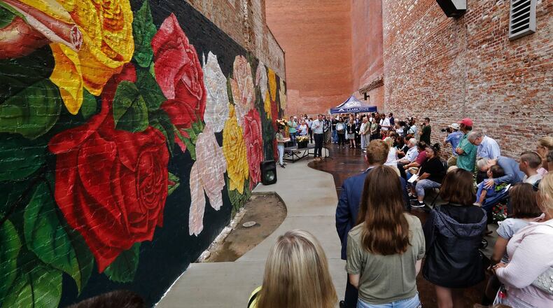 A crowd gathers for the dedication ceremony of the Rose City Mural by Mariah Kaminsky and Project Jericho Tuesday evening in downtown Springfield. BILL LACKEY/STAFF