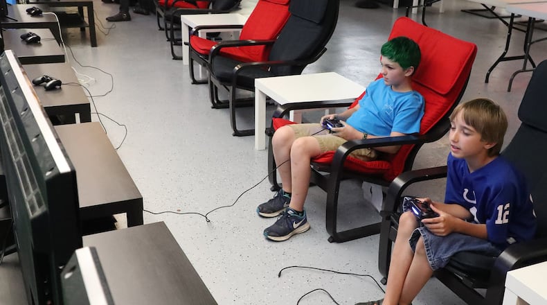 Cale Wheeler, left, and Elijah Clicquennoi play video games Thursday, May 31, 2018 at Pixel Playground in the Upper Valley Mall. Bill Lackey/Staff