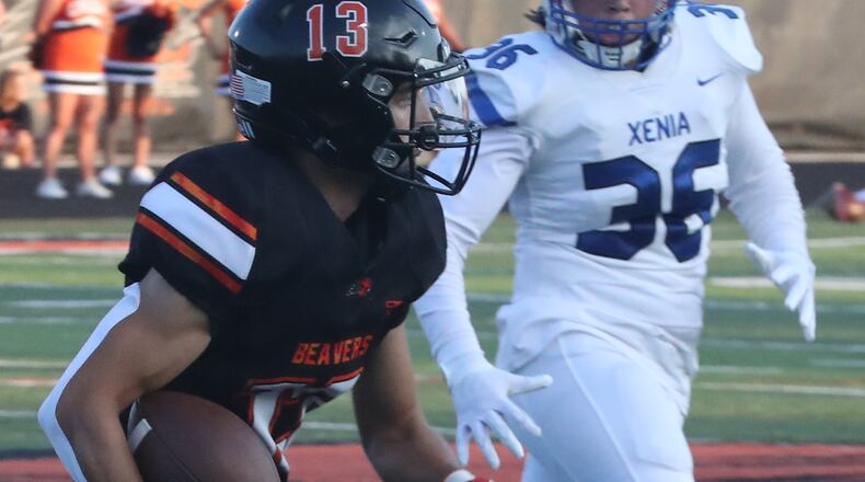 Beavercreek's Adi Hernandez tries to avoid a tackle by Xenia's Ronnie Butler during Friday's season opener. BILL LACKEY/STAFF