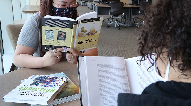 Clark State College students Gracie Perkins, left, and Jasmin Alford study about addiction in the Clark State Library. BILL LACKEY/STAFF