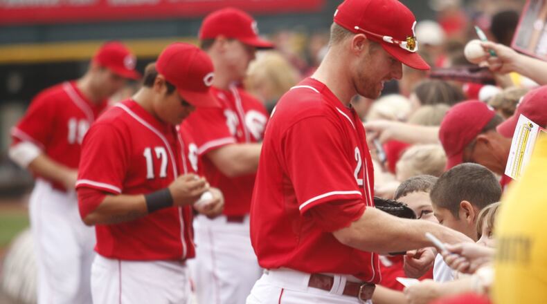 The Reds’ Zack Cozart, front, Shin-Soo Choo, Jay Bruce and Joey Votto sign autographs on Sunday, Sept. 29, 2013, at Great American Ball Park in Cincinnati.