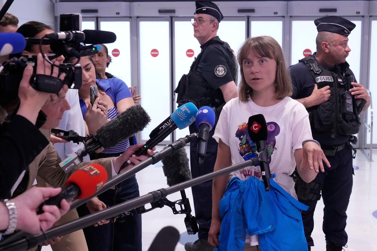 Activist Greta Thunberg answers reporters as she arrives from Israel at Charles de Gaulle airport, north of Paris, Tuesday, June 10, 2025. (AP Photo/Michel Euler)