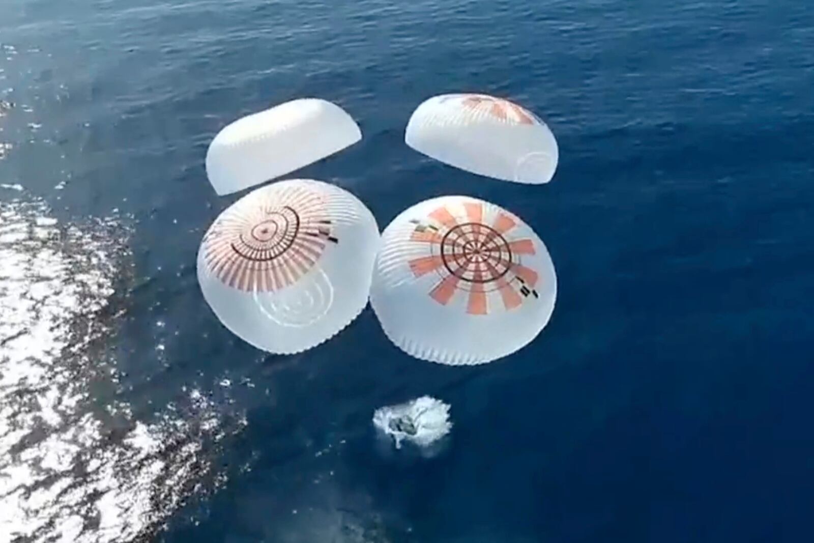 In this image from video provided by SpaceX, the Dragon capsule carrying four space tourists splashes down in the Pacific Ocean off the coast of California on Friday, April 4, 2025. (SpaceX via AP)