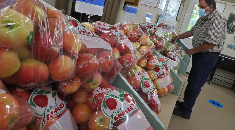Chris Stevens was busy setting up for the opening for the Apple Shed at the Stevens Bakery and Orchard on Thackery Road Thursday. BILL LACKEY/STAFF