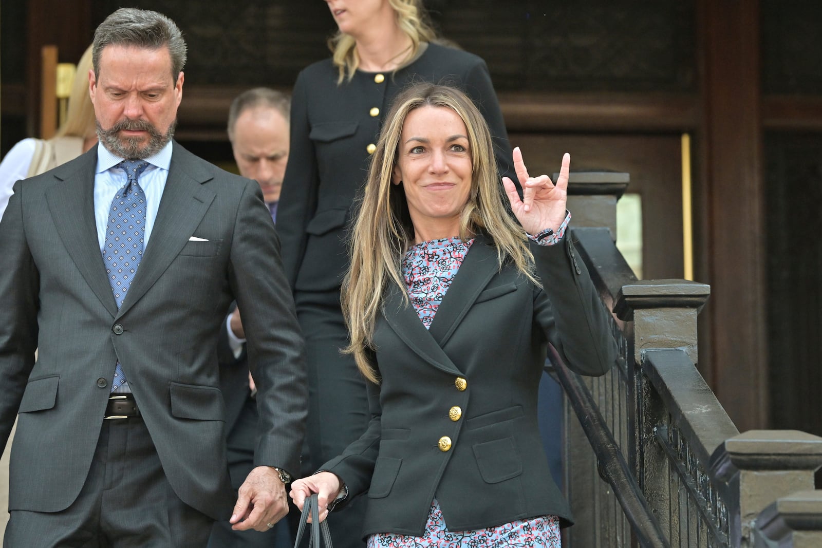 Karen Read, right, gestures to supporters as she and attorney Alan Jackson, left, leave the Dedham, Mass. courthouse, after the judge issued instructions to the jury in Read's trial at Norfolk Superior Court, Friday, June 13, 2025, in Dedham, Mass. (AP Photo/Josh Reynolds)