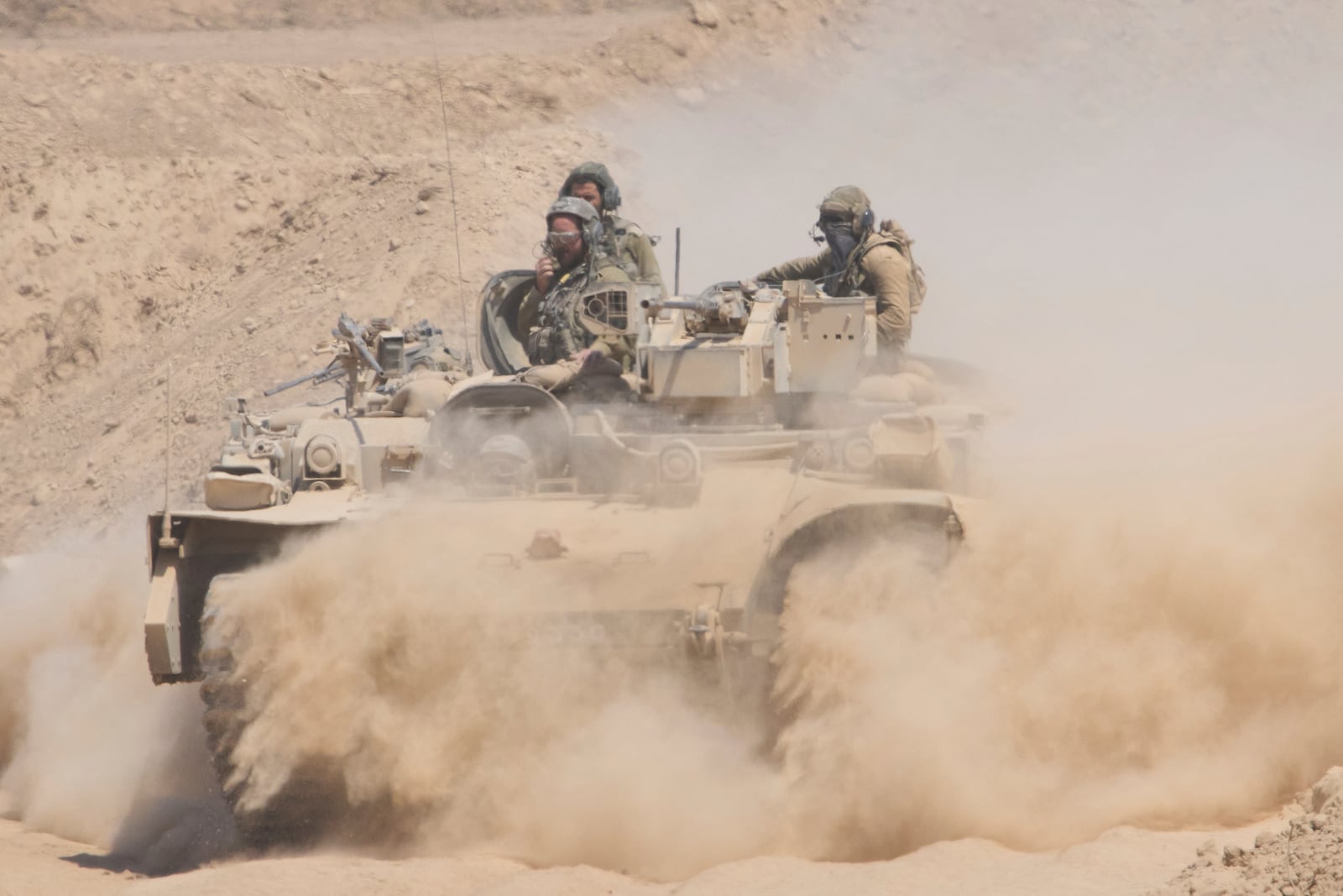 Israeli soldiers drive on their armored personnel carrier back from inside the northern Gaza Strip into southern Israel, Tuesday, July 29, 2025. (AP Photo/Ariel Schalit)
