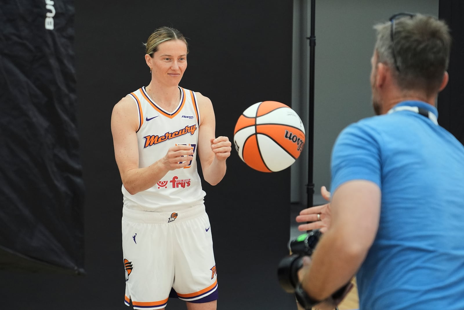 Phoenix Mercury guard Sami Whitcomb, left, of Australia, reaches for a ball tossed to her during a photo shoot at Mercury Media Day at the team's WNBA basketball training facility, Wednesday, April 30, 2025, in Phoenix. (AP Photo/Ross D. Franklin)
