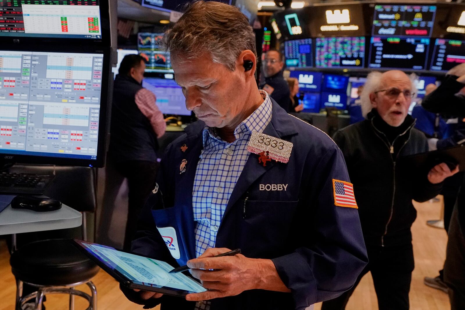 Trader Robert Charmak, left, works on the floor of the New York Stock Exchange, Friday, April 11, 2025. (AP Photo/Richard Drew)