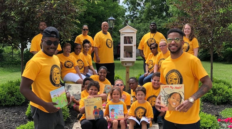 The co-founders of The Conscious Connect, Inc. Moses B. Mbeseha, left, and Karlos L. Marshall, right, in this file photo stand with children and community members at a reading park they created on Woodward Avenue in Springfield. The Conscious Connect's newest initiative will including working with teens through a reading project to help them learn how to advocate against racism. CONTRIBUTED.