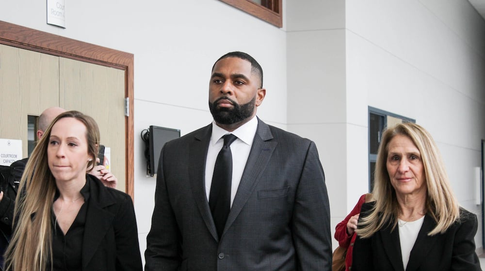 Former Michigan football coach Sherrone Moore arrives for a court hearing with his wife, Kelli Moore, left, and attorney Ellen Michaels, Friday, March 6 2026, at Washtenaw County 14A-1 District in Ann Arbor, Mich. (Jordyn Pair/Ann Arbor News via AP)