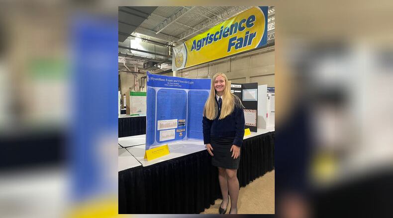 Global Impact STEM Academy FFA member Terra Choi with her project, "The Effects of Different Acid-Based Cleaners on Aluminum."