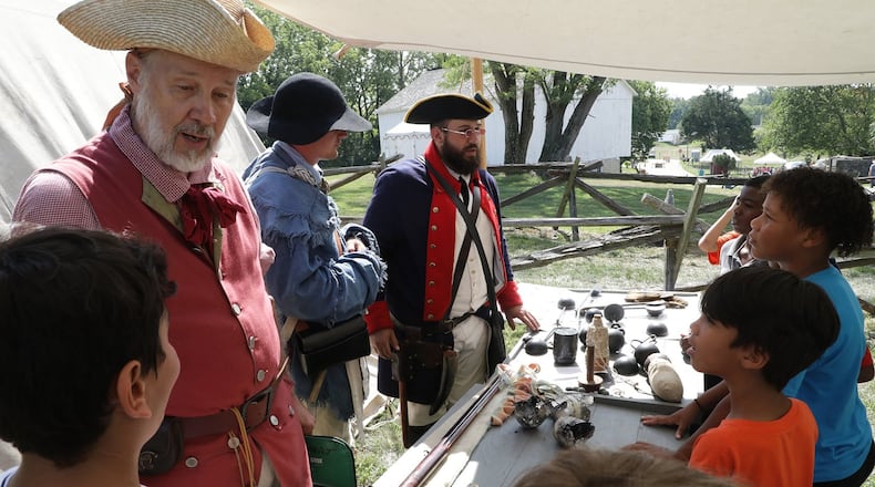 Students learn about military weapons and tactics in the 18th century Friday during Education Day at the Fair at New Boston last year. This year's festival has been canceled. BILL LACKEY/STAFF