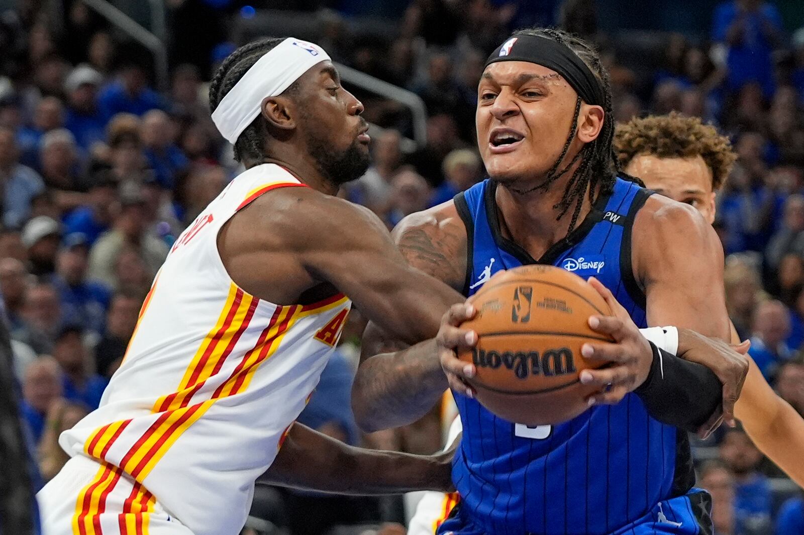 Orlando Magic forward Paolo Banchero, right, is fouled by Atlanta Hawks guard Caris LeVert, left, as he goes up for a shot during the second half of an NBA play-in tournament basketball game, Tuesday, April 15, 2025, in Orlando, Fla. (AP Photo/John Raoux)