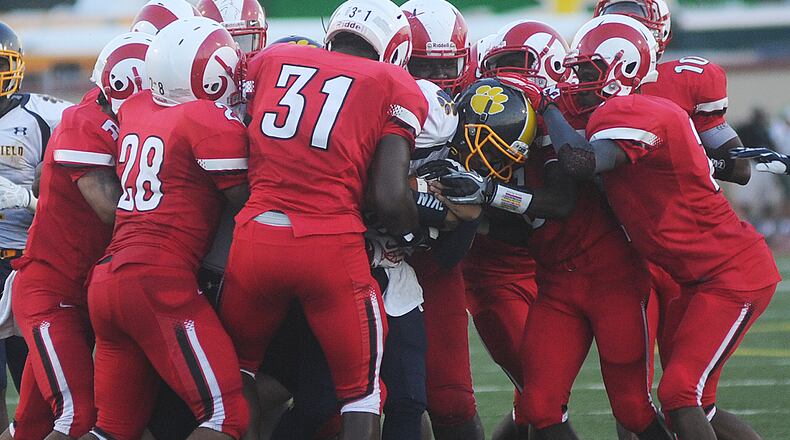 Springfield's Derek Williams is tackled by most of the Trotwood defense Friday night at Welcome Stadium. MARSHALL GORBY / STAFF
