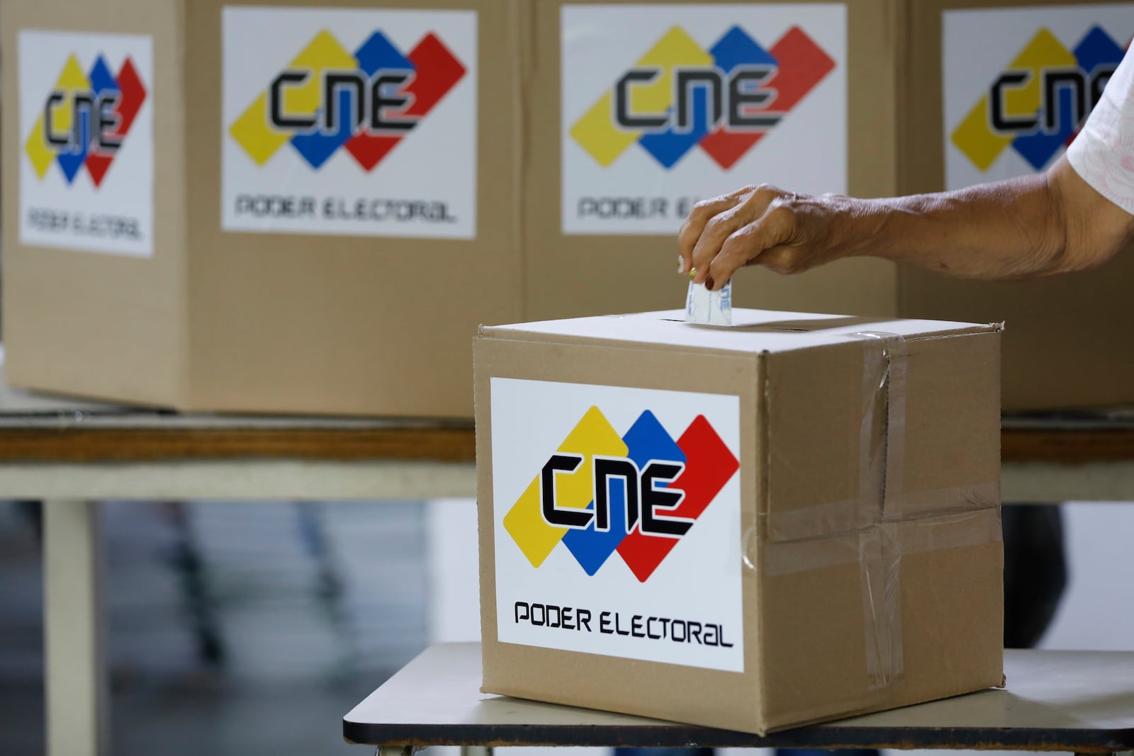 A woman casts a mock vote during a rehearsal for the upcoming regional election, in Caracas, Venezuela, Saturday, May 10, 2025. (AP Photo/Cristian Hernandez)