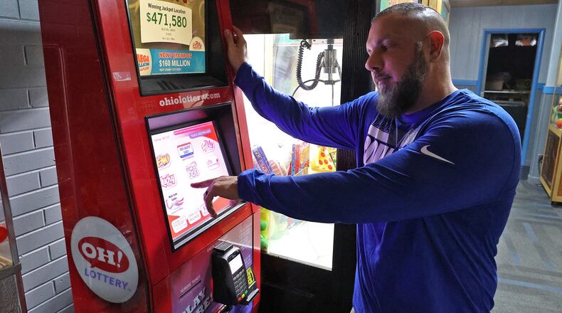 Demetri Zavakos, manager of Victory Lanes bowling alley in Springfield, describes how sports betting will work on an Ohio Lottery kiosk in the alley Thursday. BILL LACKEY/STAFF